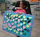 大学生街头收集“爱的拥抱”为雅安祈福